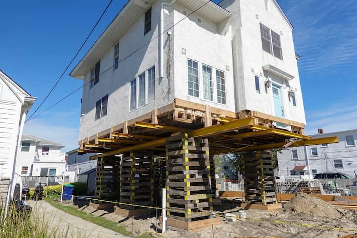 A team of professionals using specialized equipment to raise a house in Fishers, preparing it for elevation and renovation